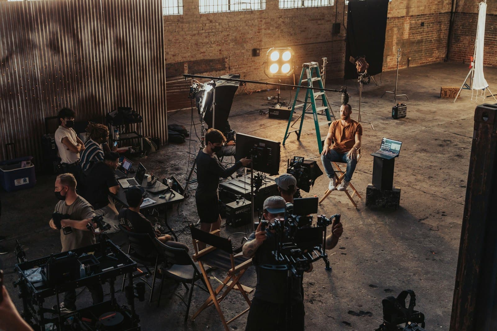 Film crew setting up lighting and camera equipment on set